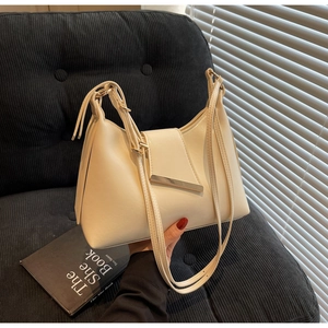 Detailansicht der beigen Halbmond-Ledertasche mit minimalistischer goldener Schnalle