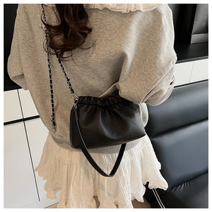Détail du sac nuage plissé noir avec chaîne argentée et bandoulière en cuir