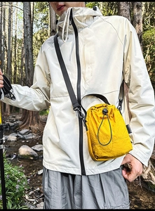 Close-up of lightweight yellow drawstring crossbody bag with textured water-resistant fabric