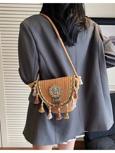 Bohemian woven crossbody bag with ethnic beaded emblem and decorative tassels