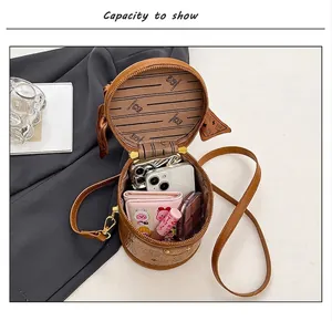 Interior view of brown leather round bag showing ample space for phone and makeup