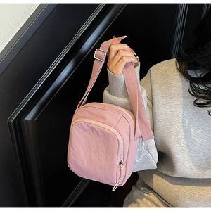 Detailansicht der rosa Nylon-Umhängetasche für Handys mit Reißverschluss und Tragegurt