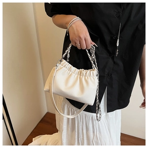 Détail du sac plissé blanc cassé à texture lychee et chaîne argentée élégante