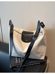 Minimalist off-white waterproof nylon tote bag with black straps and metal buckle design