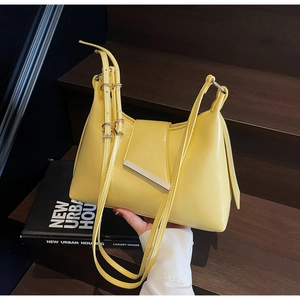 Detail der leuchtend gelben Lackleder-Schultertasche mit Silberleiste und Doppelriemen