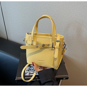 Dettaglio borsa tote giallo zenzero in pelle a grana litchi con fibbia argentata e tracolla