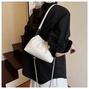 Vue détaillée du sac nuage blanc plissé avec bandoulière en chaîne sur un mannequin