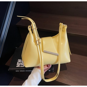 Details einer leuchtend gelben Trapez-Schultertasche mit eleganter silberner Schnalle