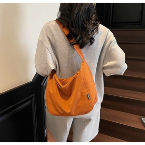Detail of orange canvas tote bag with adjustable strap and side FASHION label