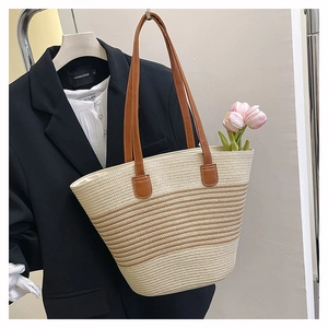 Détail du sac cabas en paille tissée avec anses en cuir marron et rayures beige