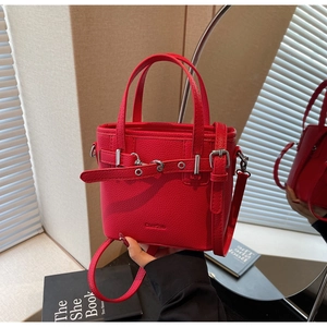 Dettaglio borsa a secchiello in pelle rossa motivo litchi con fibbia argentata e logo