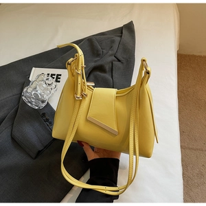 Detail der zitronengelben Ledertasche mit einzigartigem asymmetrischem Goldverschluss