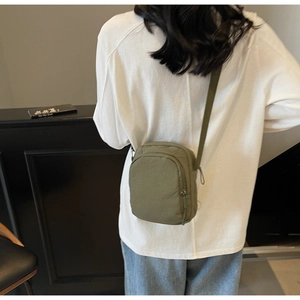 Detail der grünen Nylon-Umhängetasche mit verstellbarem Gurt, getragen von Model