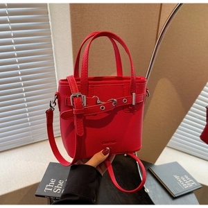 Dettaglio della mini borsa a secchiello rossa in pelle martellata con logo e fibbia