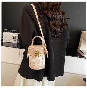 Detail of beige bucket bag with bear print and pink silk scarf wrapped handle