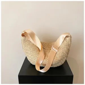 Detail of woven crescent crossbody bag with adjustable wide nylon shoulder strap