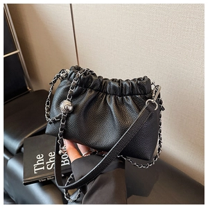 Détail du sac nuage plissé noir avec texture litchi et bandoulière en chaîne
