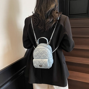 Light blue quilted mini backpack with rhinestones and silver chain straps on model
