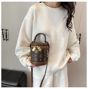 Detailed view of vintage bear pattern bucket bag with braided handle and gold charm