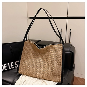 Gros plan sur le tissage en paille chevrons et les bords en cuir noir d'un sac cabas plage