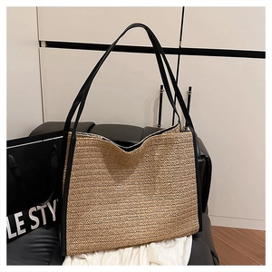 Détail du sac cabas en paille tissée avec des bandoulières en cuir noir de haute qualité