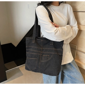 Detail of vintage denim tote bag showing decorative jean pocket stitching and texture