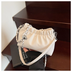Détail du sac à bandoulière blanc en cuir grainé avec boule argentée et chaîne élégante
