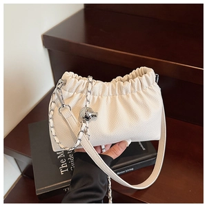 Détail du sac plissé crème avec texture litchi et bandoulière en chaîne argentée