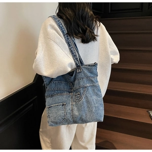 Detail of vintage blue denim tote bag featuring jeans pocket design and frayed texture