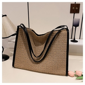 Détail de la texture tissée en V et des poignées en cuir noir d'un sac cabas de plage