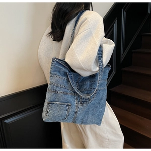 Detail view of denim tote bag with reconstructed jeans pocket design and washed texture