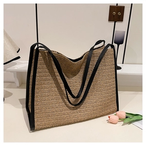 Vue détaillée du sac cabas en paille avec bandoulières en cuir noir et motif chevrons