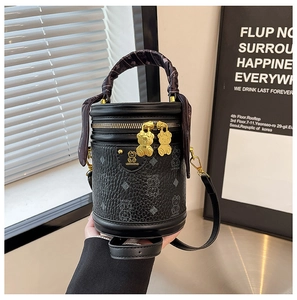 Detail of black cylindrical bucket bag with bear print, lychee texture, and silk scarf handle