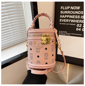 Detailed macro view of pink cylinder bucket bag featuring bear print and silk scarf handle