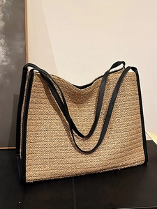 Grand sac cabas en paille avec lanières en cuir noir et motif à chevrons dans un studio chic