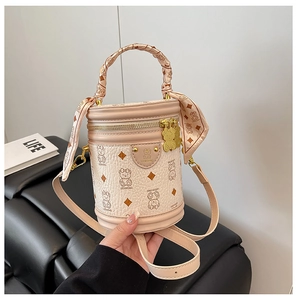 Close-up of barrel bucket bag featuring cartoon bear patterns and silk scarf handle