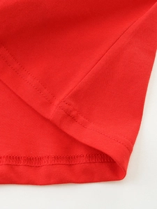 Close-up of red knit cotton dress hem with high-quality double-needle stitching detail