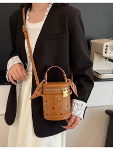 Brown cylinder handbag with bear print and silk scarf handle shown on a model