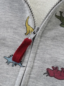 Gray zip-up kids hoodie with colorful dinosaur prints and red fabric zipper pull