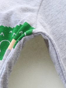 Close-up of durable stitching and dinosaur print on boys' grey cotton knit long sleeve T-shirt