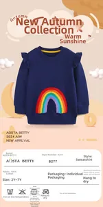 Macro detail of navy girls sweatshirt with rainbow embroidery and ruffled shoulders