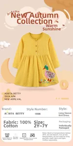 Dettaglio dell'abito in cotone giallo a pois con ricamo di anatra e bottoni