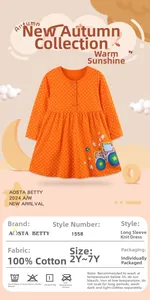 Détail de la robe en coton pour filles avec pois orange et broderie de tracteur