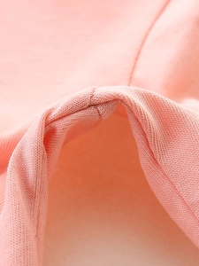 Vue macro détaillée du tissu en coton tricoté rose pêche doux pour robe de petite fille