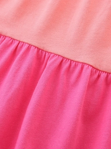 Gros plan du tissu en coton tricoté avec coutures corail et rose pour robes de filles