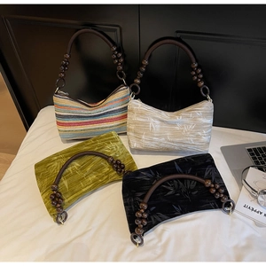 Detail of four retro beaded handle handbags with colorful stripes and tropical leaf prints