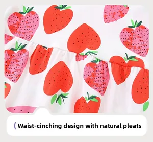 Detail van de aardbeienprint op witte katoenen jurk met taille en natuurlijke plooien