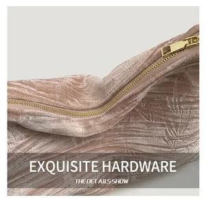 Close-up of pink velvet handbag featuring embossed bamboo leaves and golden metal zipper