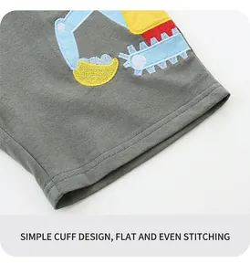Detail of boys' grey knit shorts with colorful machine embroidery and flat seam stitching
