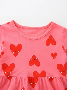 Pink cotton girls dress with round neck and cute red heart face prints on a white background